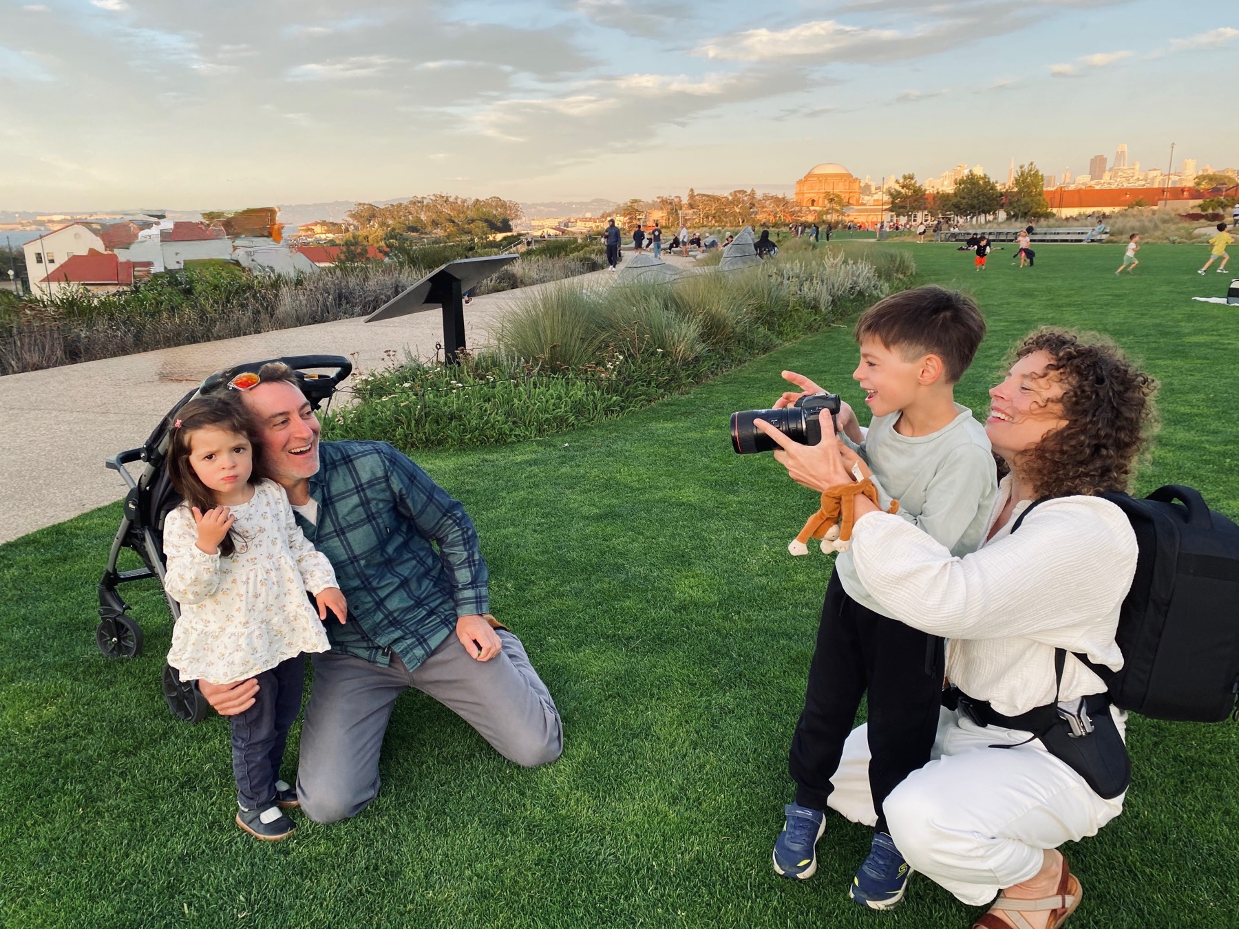 Cass photographing a family at Presidio Tunnel Tops in San Francisco, one of the kids holding on to her camera lens