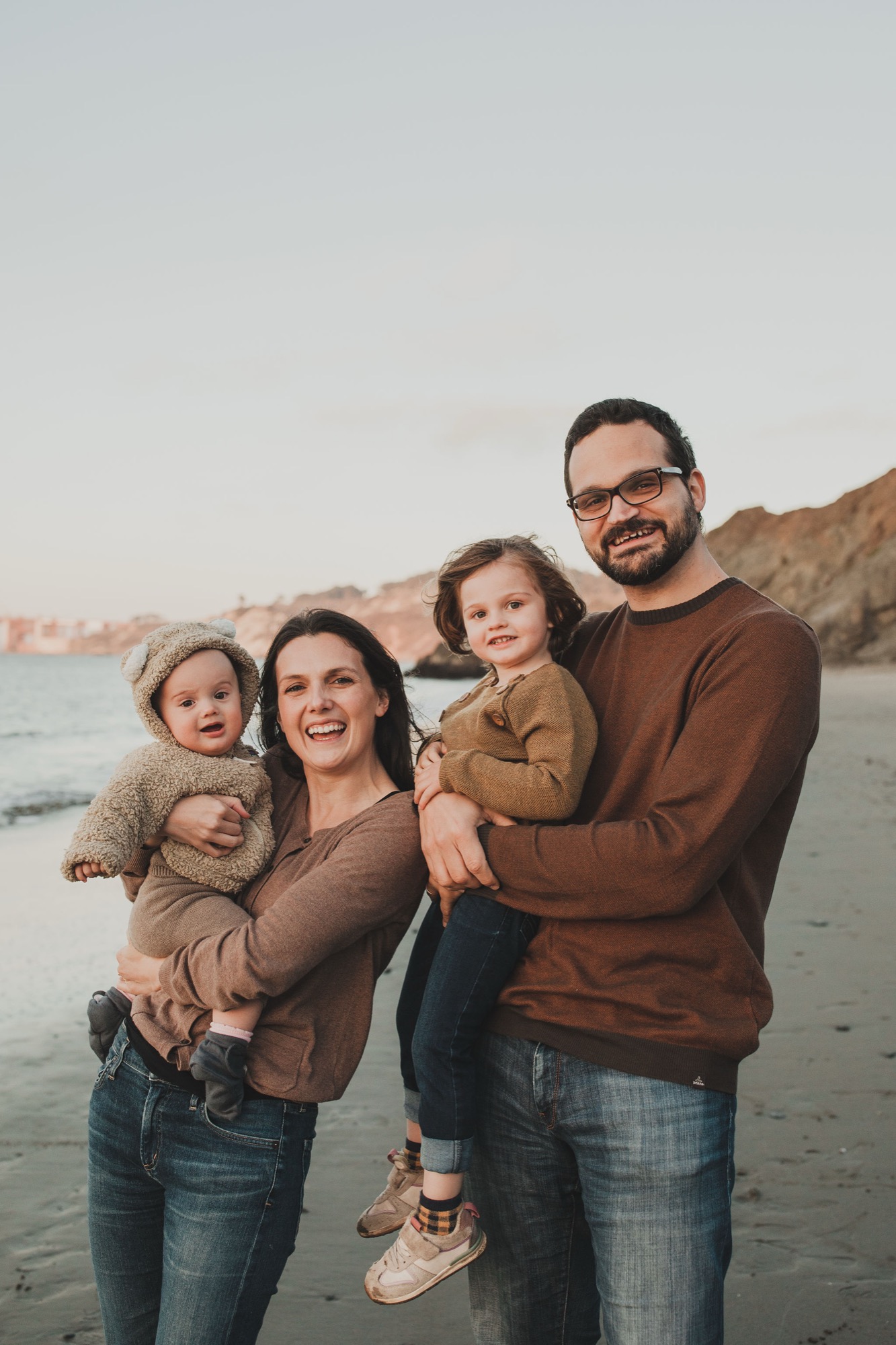 Family at China Beach in San Francisco all wearing shades of brown, from deep coffee to caramel to sand, with denim
