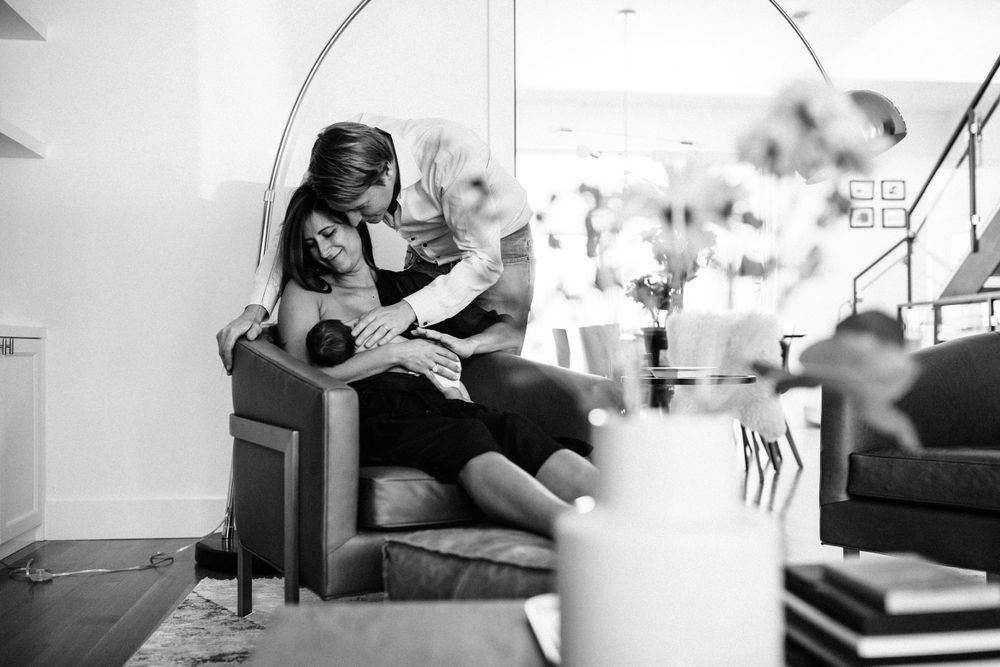 Parents with newborn in a bright living room — in-home lifestyle newborn session in Marin County
