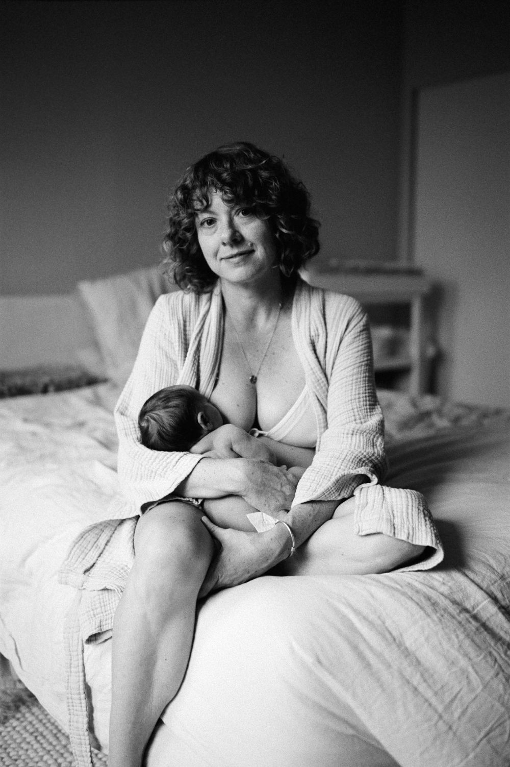 Intimate black and white newborn photography on a bed